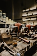 Close-up of a sleek espresso machine surrounded by natural wood shelves.