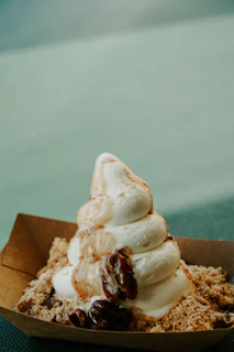 Frozen yogurt swirl with crushed nuts and a drizzle of dark chocolate sauce.