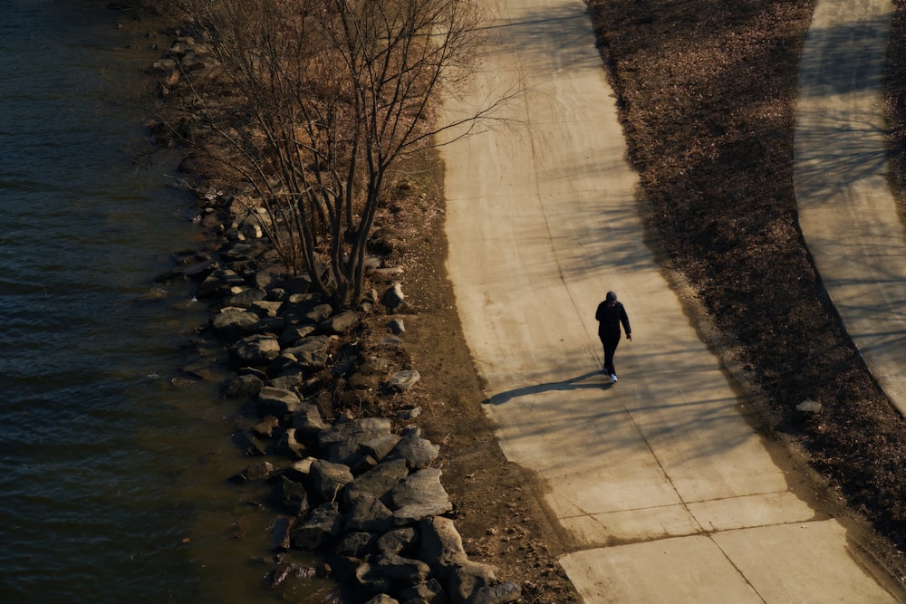 a person walking down a path next to a body of water