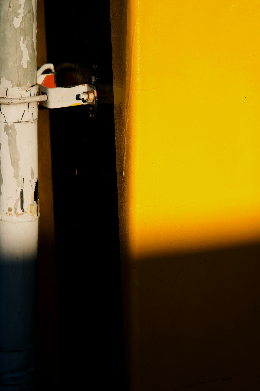 a close up of a white pipe with a yellow wall in the background