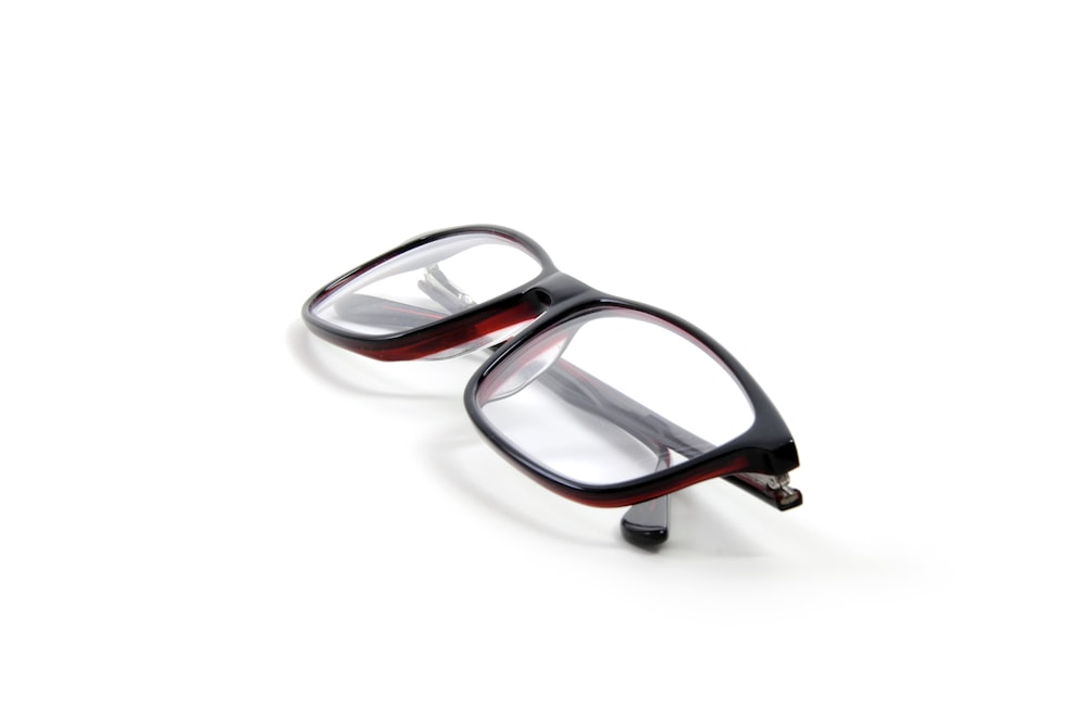 a pair of glasses sitting on top of a white surface