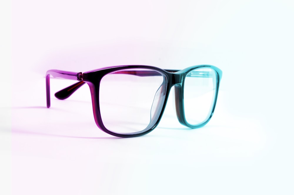 a pair of glasses sitting on top of a white surface