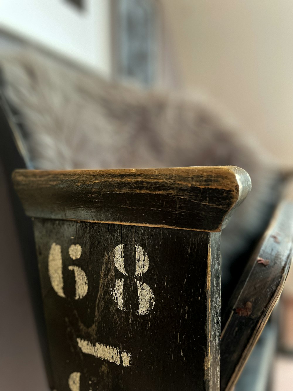a close up of a wooden chair with writing on it
