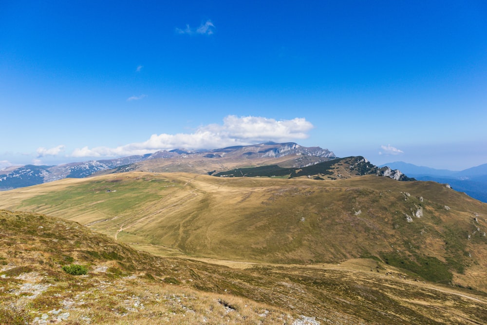 a view of a mountain range from the top of a hill