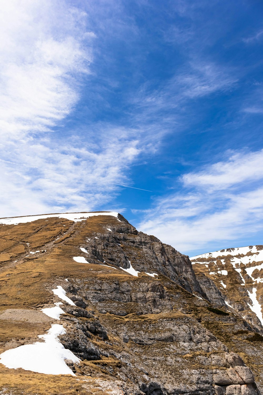 a man flying a kite on top of a snow covered mountain