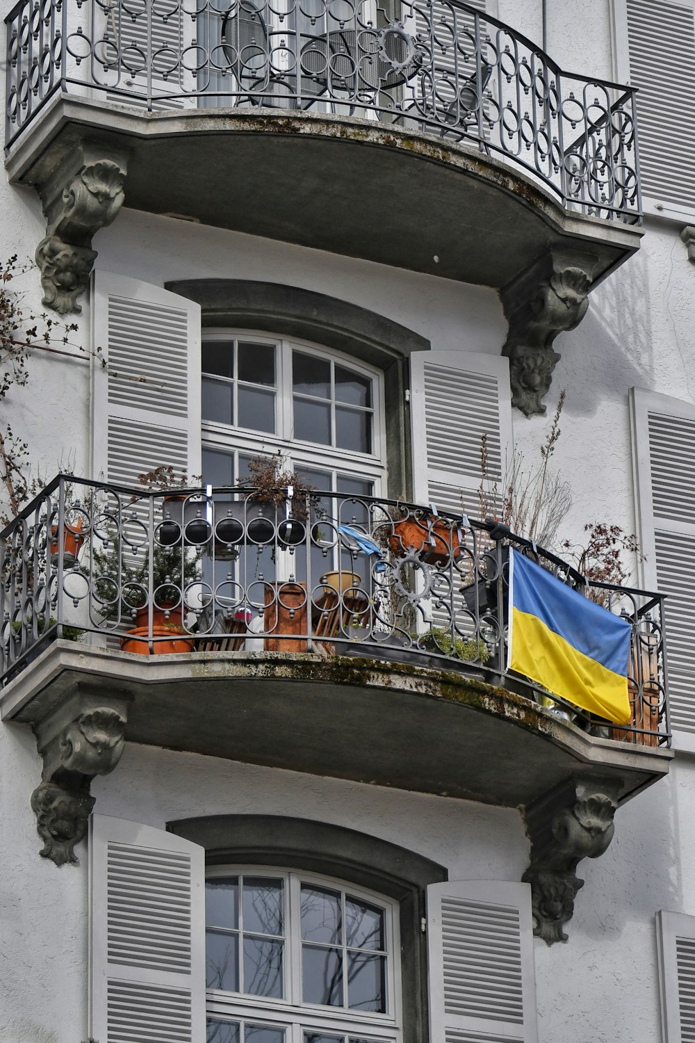 a balcony with a flag on it next to a building