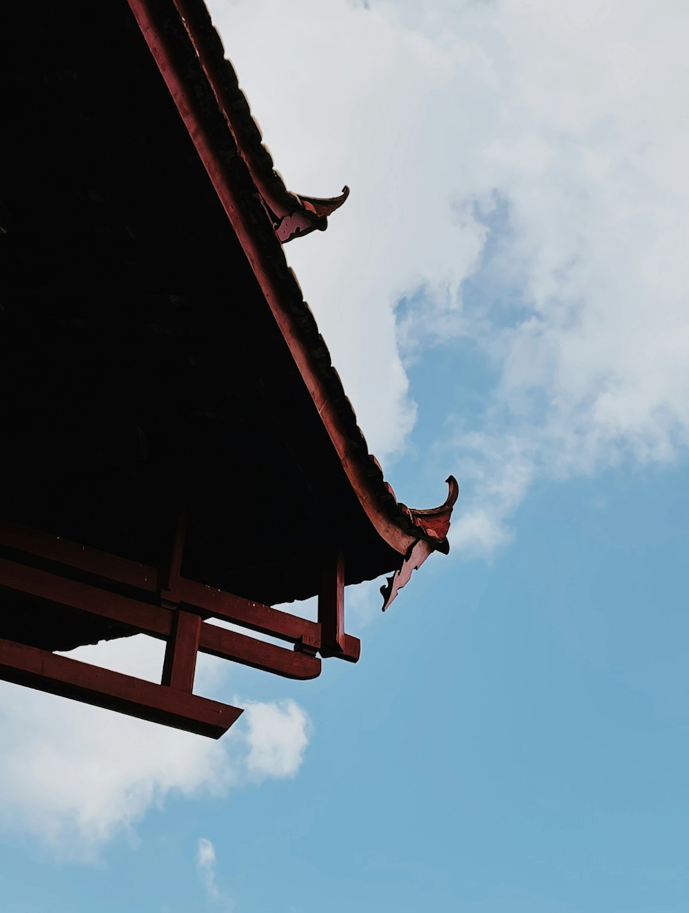 a bird flying in the air over a roof