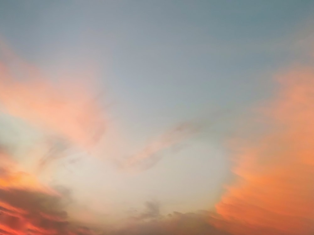 a plane flying in the sky with a sunset in the background