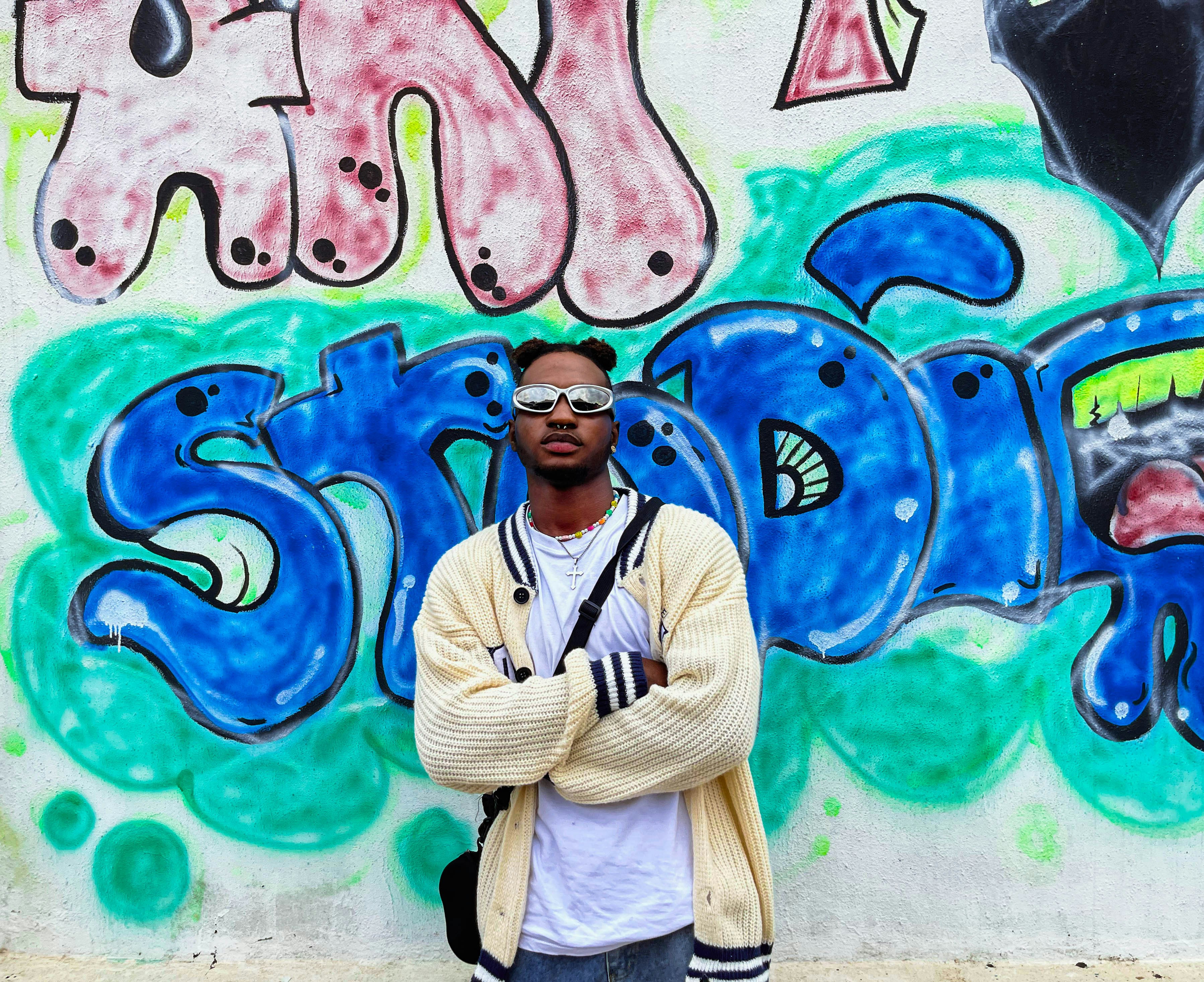 a man standing in front of a graffiti wall