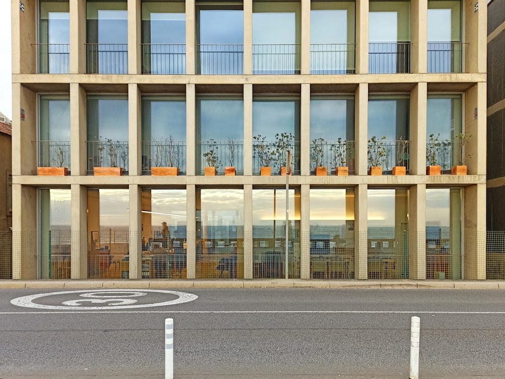 a building with a lot of windows and plants on the balconies