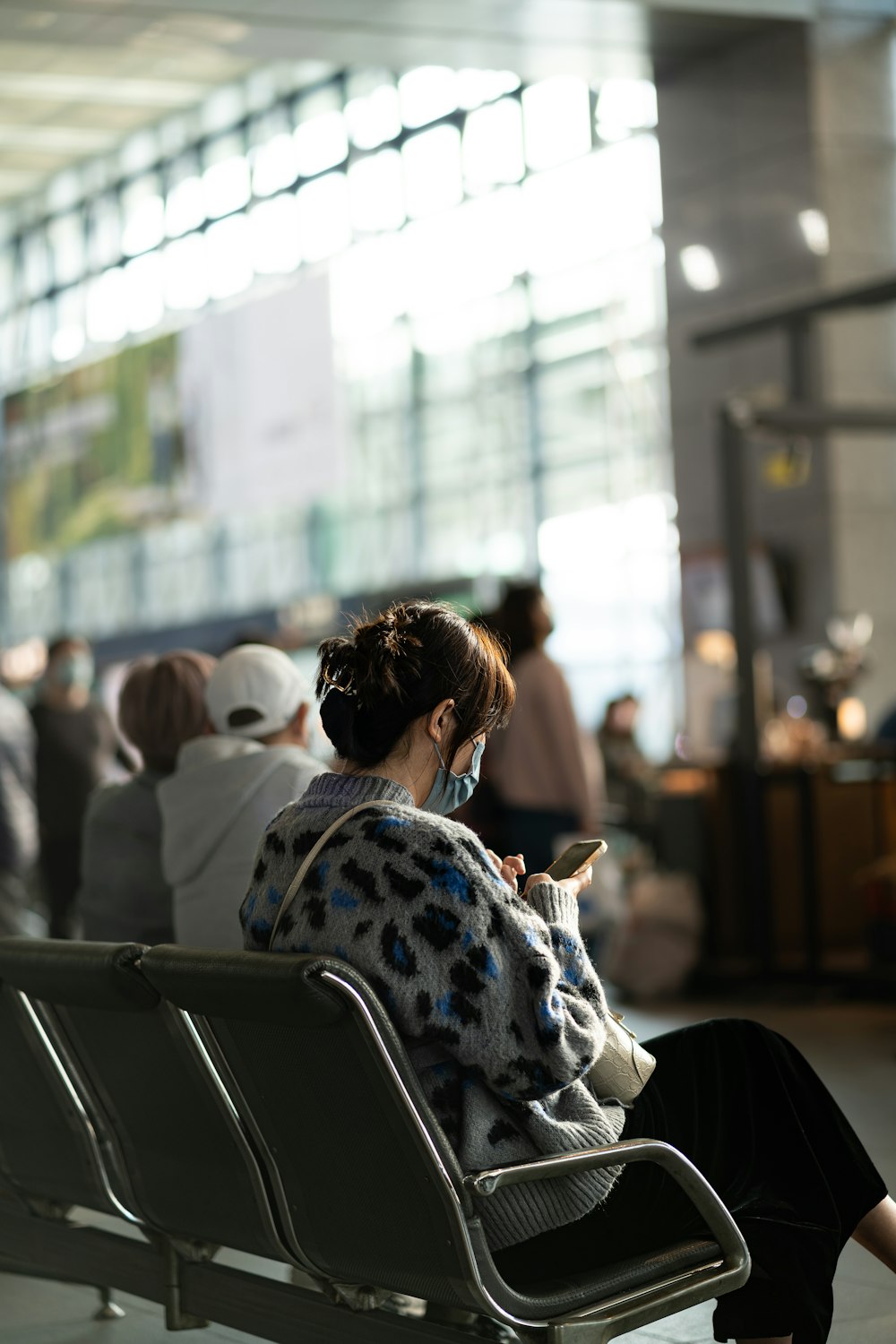 a woman sitting on a bench using a cell phone