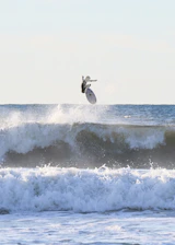Close-up of a surfer mid-air with a camera capturing the perfect shot.
