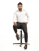 Stylish man with a well-groomed beard and textured haircut sitting in a cozy barber chair.