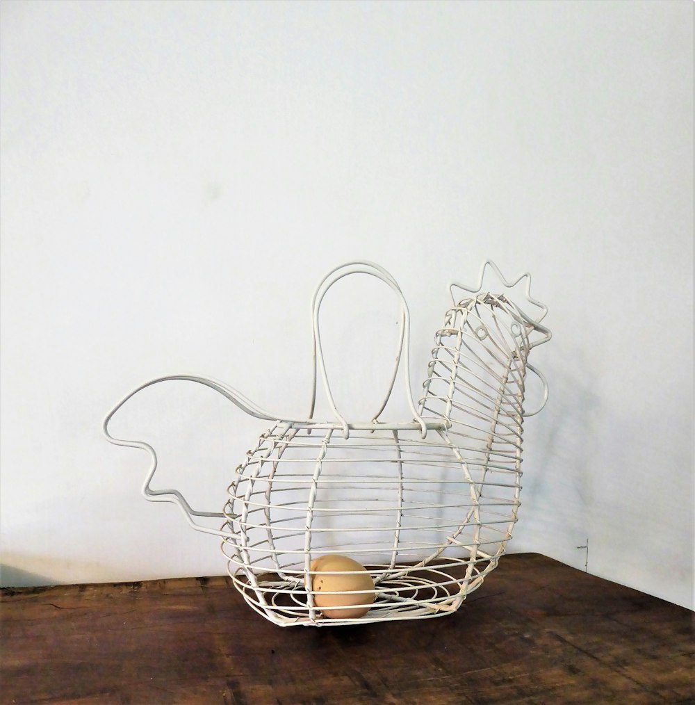 a metal basket with two eggs inside of it