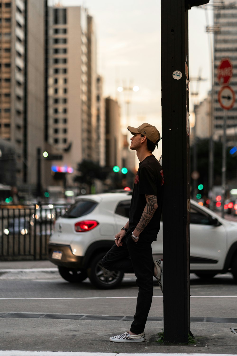 a man standing on the side of a street next to a traffic light