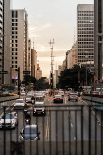 a city street filled with lots of traffic next to tall buildings