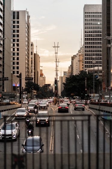 a city street filled with lots of traffic next to tall buildings