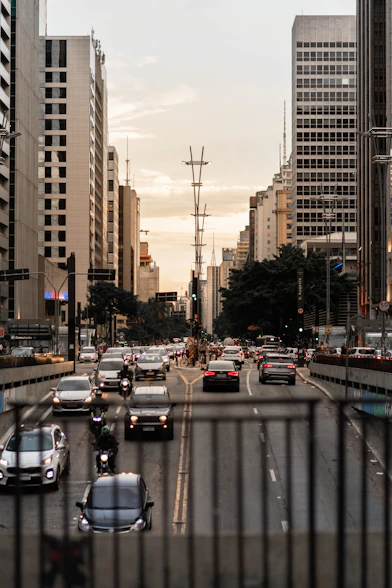 a city street filled with lots of traffic next to tall buildings