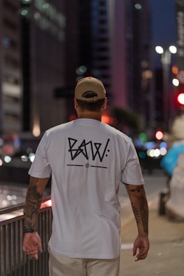 Urban night scene with a person sporting Culture Clothing streetwear under city lights.