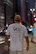 A person wearing a t-shirt with bold, colorful animated drawing walking in the city.