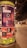 A cylindrical outdoor advertisement pillar displays multiple posters for upcoming music events. The prominent poster advertises Sr. Chinarro performing at Sala Wolf on February 10. Other posters announce concerts by Kevin Johansen on February 1, Christina Rosenvinge on February 4, and Núria Graham on February 17. The scene is set on a dimly lit street at night, with blurry figures and streetlights in the background.