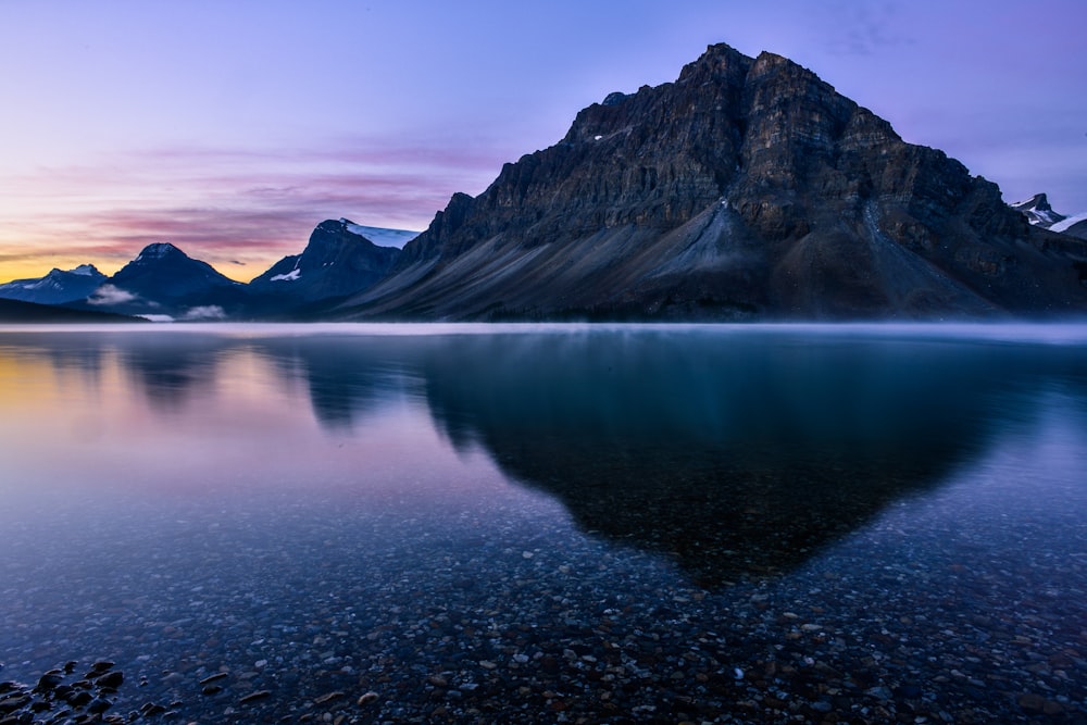 a mountain is reflected in the still water of a lake