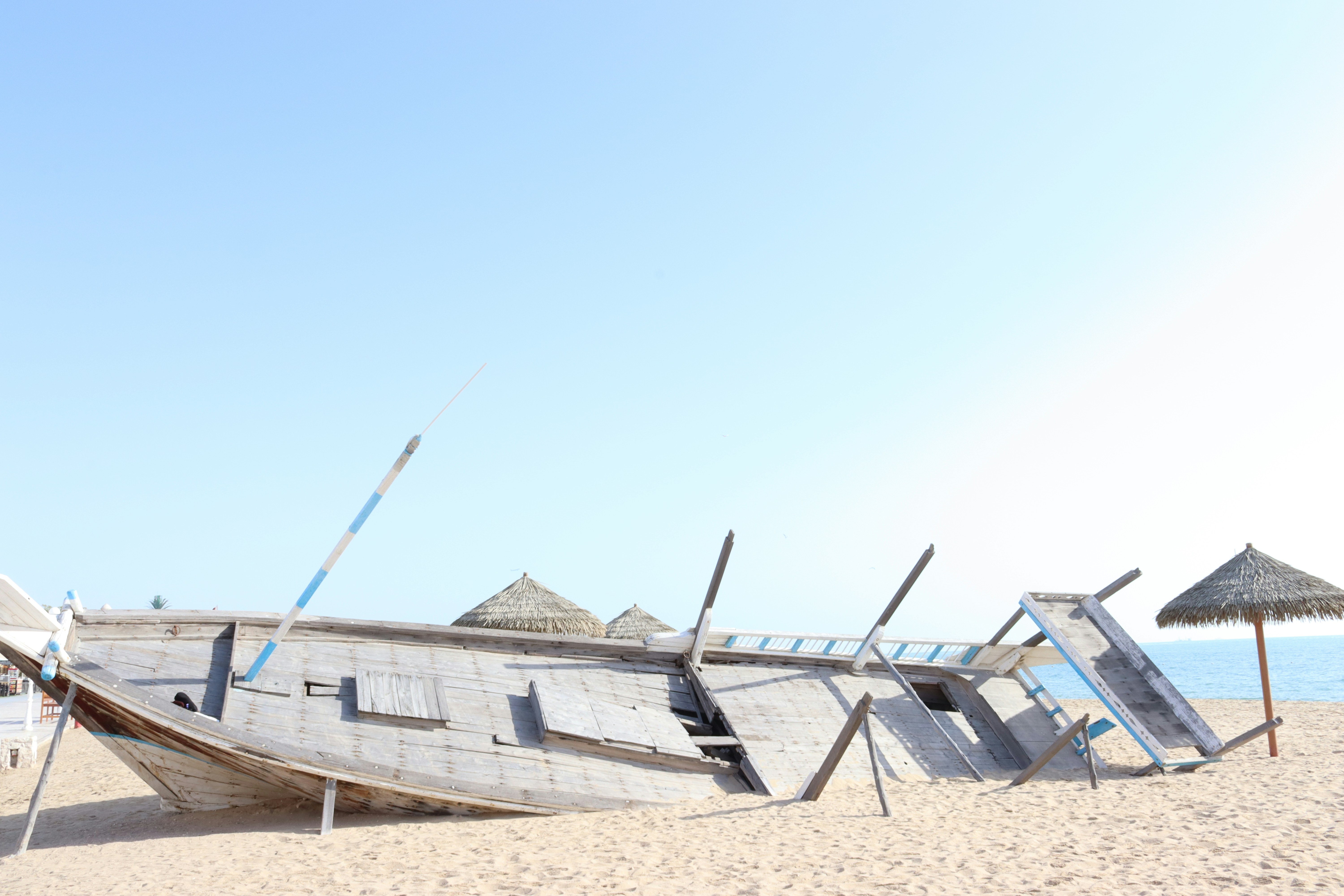 a boat sitting on top of a sandy beach