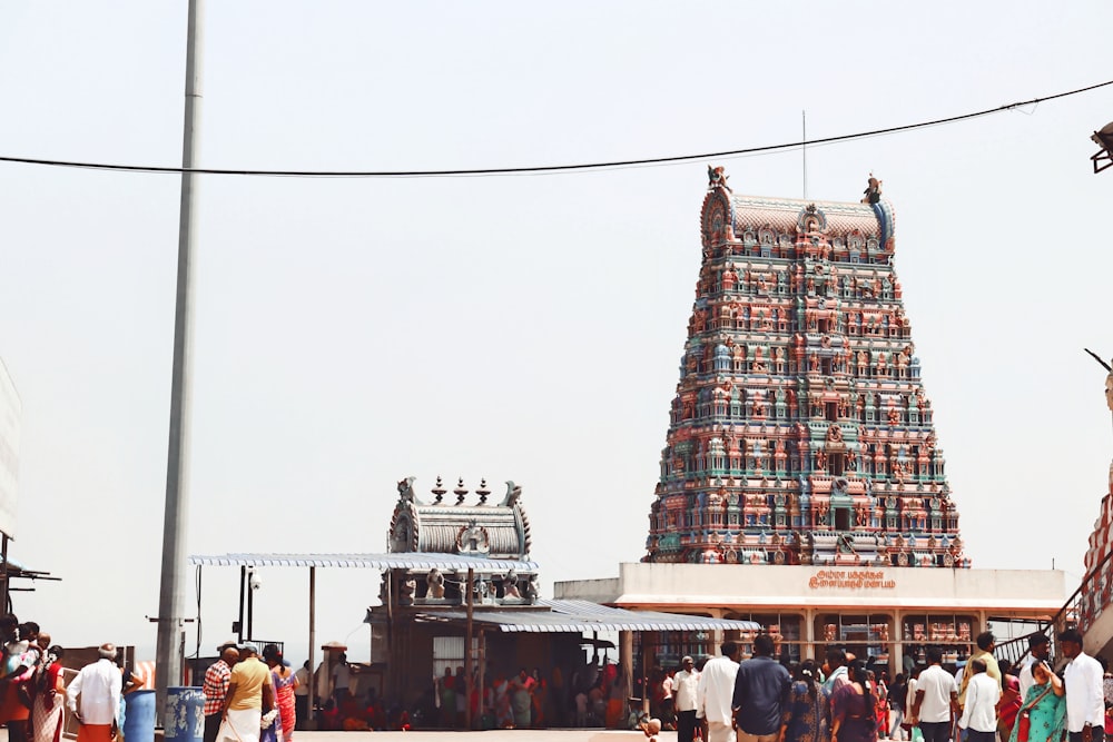 a group of people standing in front of a tall tower