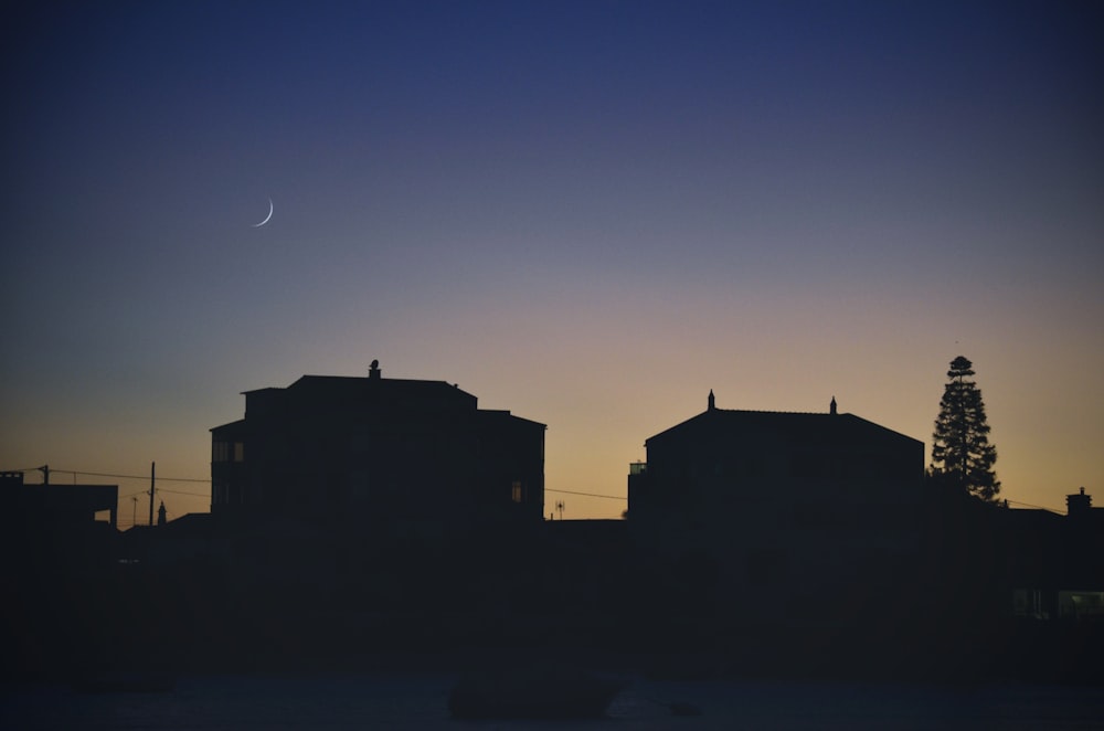 a silhouette of a building with a crescent in the sky