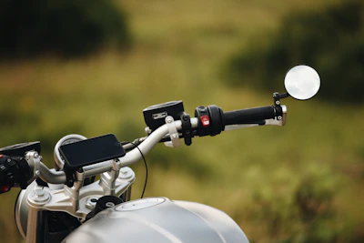 Close-up of a sleek motorcycle phone mount securely holding a smartphone on a bike handlebar.