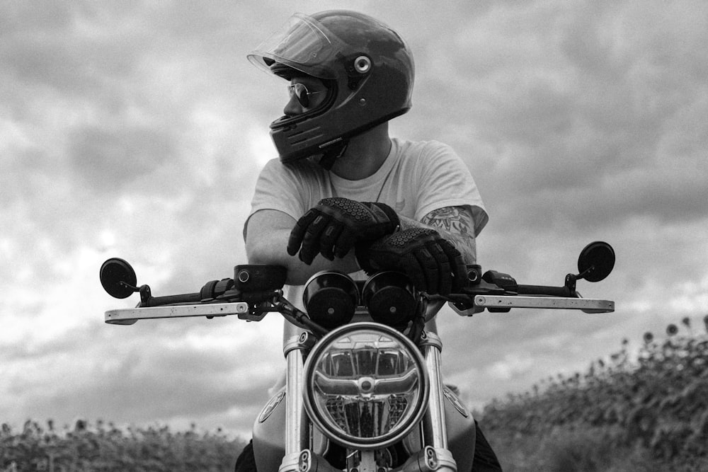 a black and white photo of a person on a motorcycle