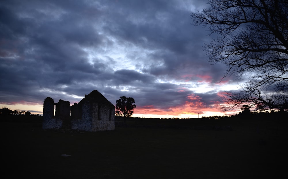 a graveyard in the middle of a field under a cloudy sky