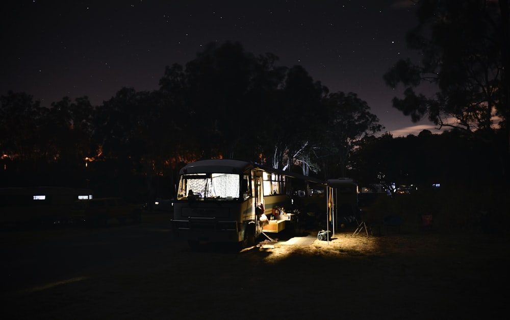 a bus parked in a field at night