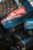 A close-up view of mechanical components of a vehicle featuring a prominent tire and engine parts. The vehicle sports a sticker with 'Dakar Classic' and 'Saudi Arabia' along with the number 707, suggesting participation in a rally event.
