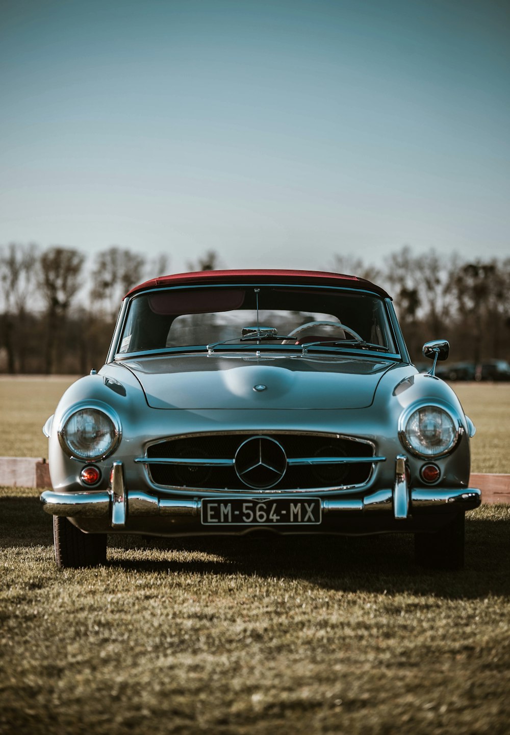 a mercedes benz sports car parked in a field