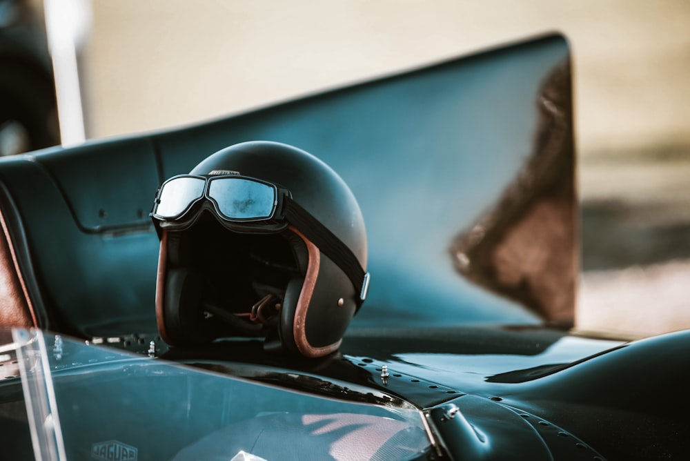 un casco y gafas en el capó de un coche