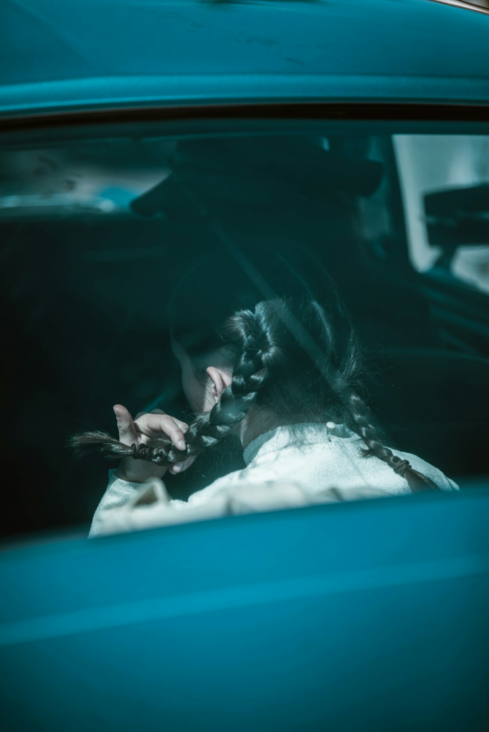 a woman sitting in a car talking on a cell phone