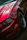 Side view of a shiny sports car with a clear protective film being applied by a technician.