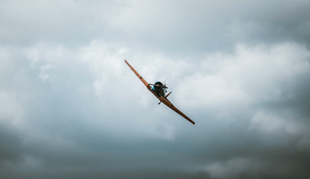 a small airplane flying through a cloudy sky