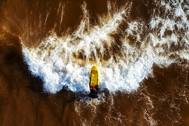 A surfer catching a wave with a GoPro attached to their board, capturing the thrill of the ocean