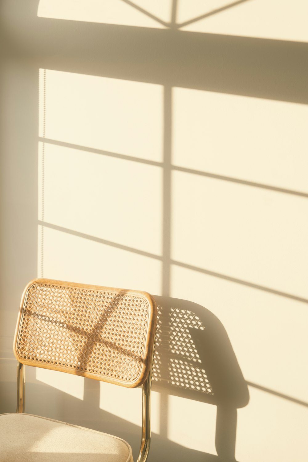 uma cadeira sentada ao lado de uma janela em uma sala