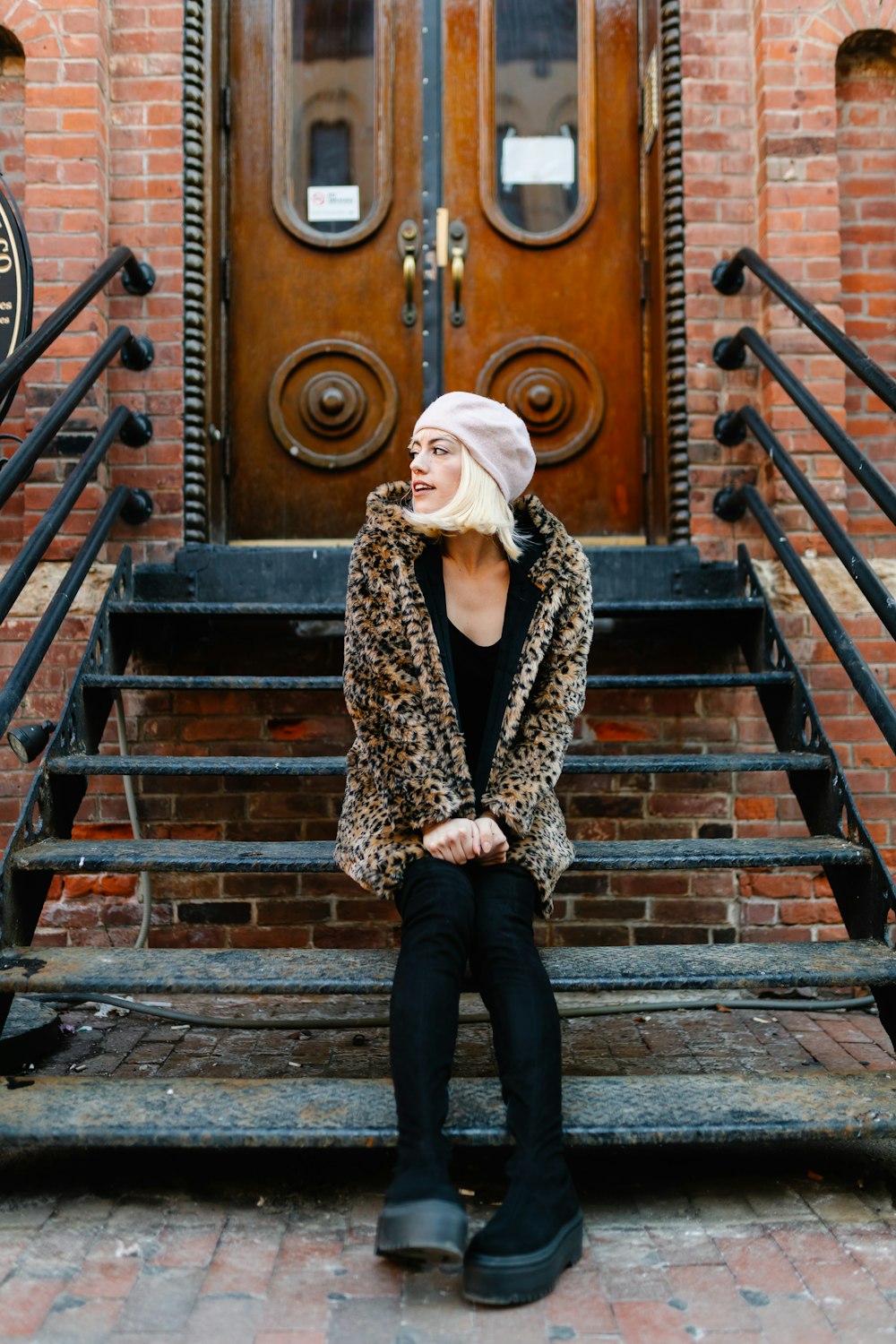 a woman sitting on a bench in front of a door