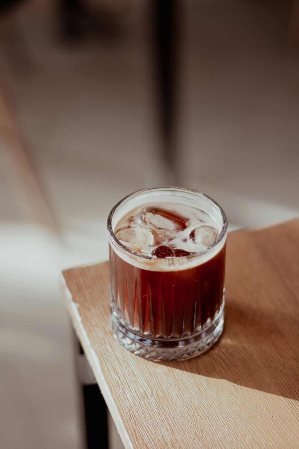 a glass of liquid sitting on top of a wooden table