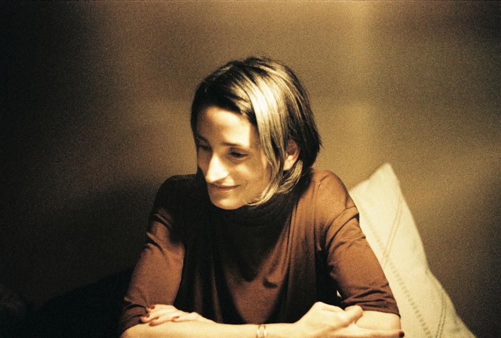 a woman sitting on a bed with her arms crossed