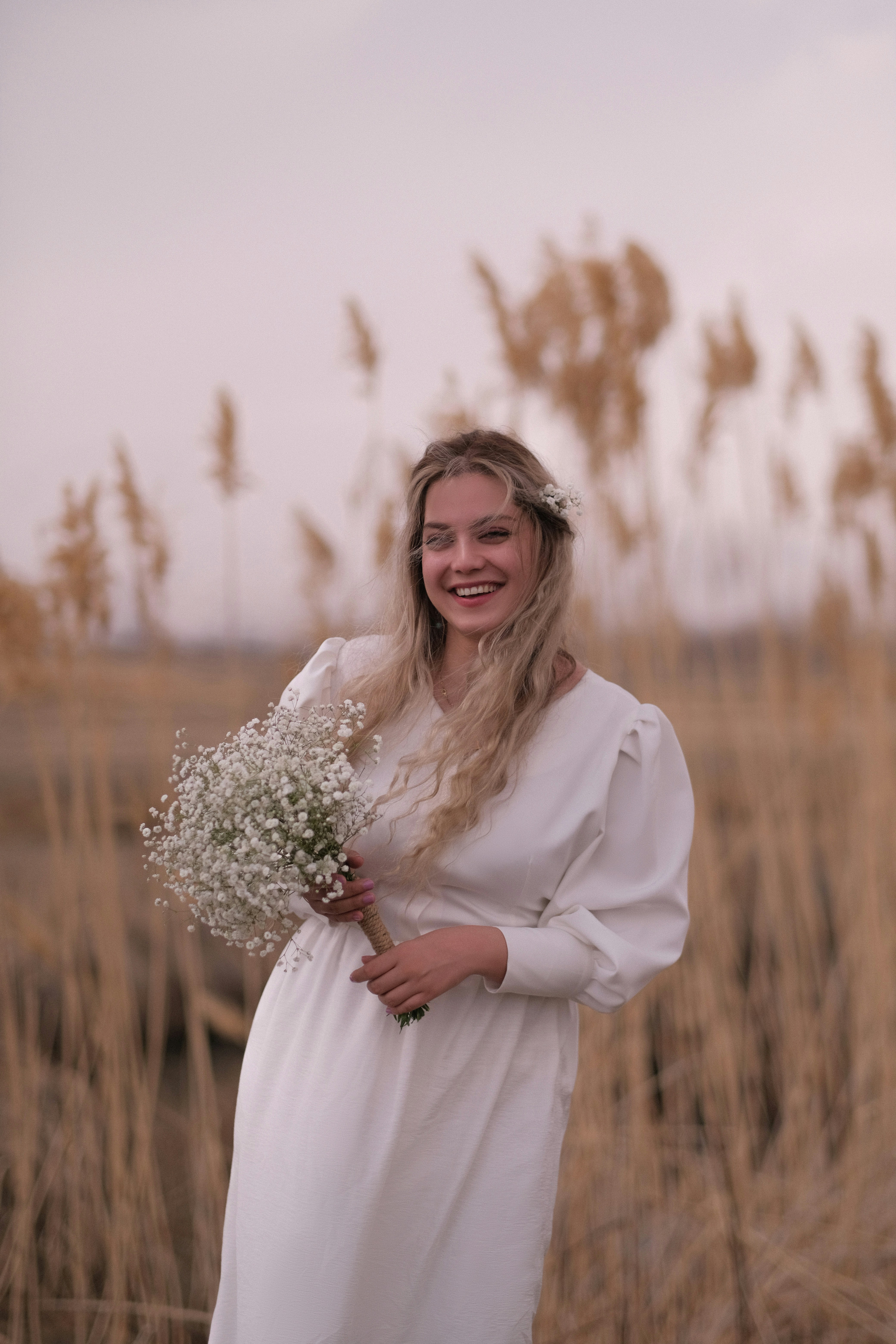 a woman in a white dress holding a bouquet of flowers