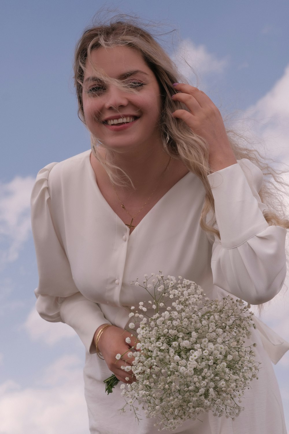 a woman in a white dress holding a bouquet of flowers