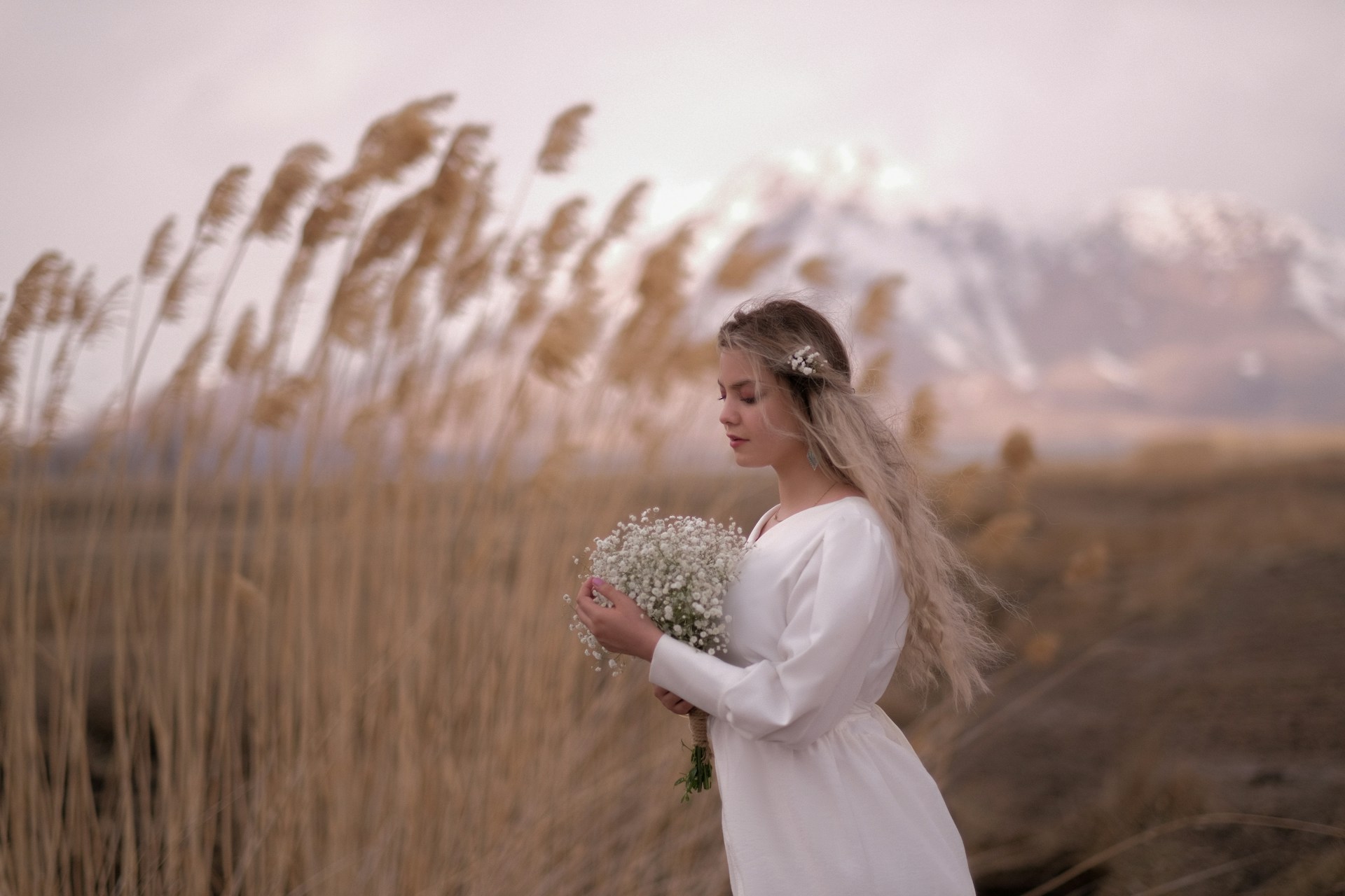 a woman in a white dress holding a bouquet of flowers