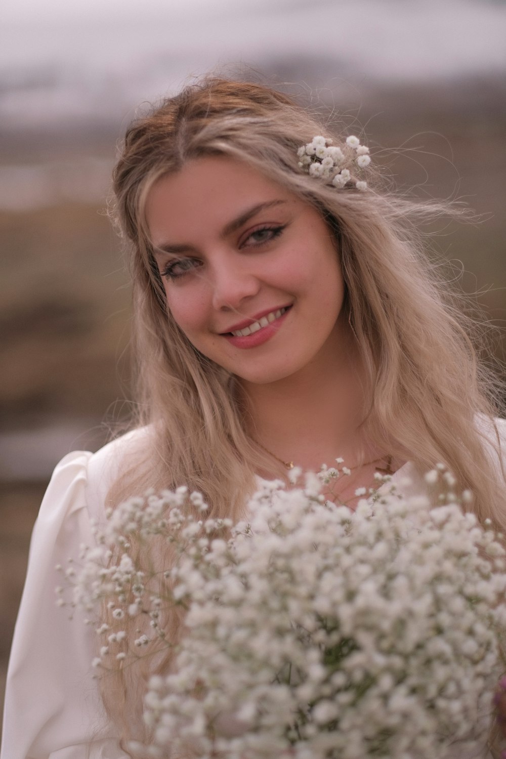 a woman in a white dress holding a bouquet of flowers