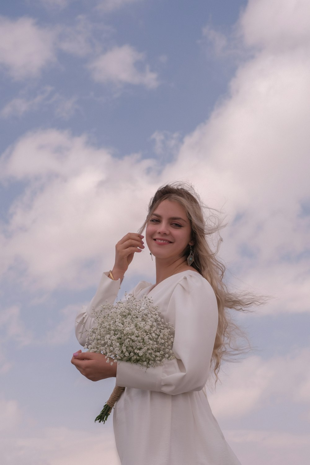 a woman in a white dress holding a bouquet of flowers