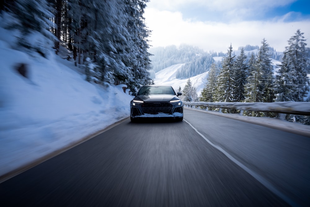 a car driving down a snowy mountain road